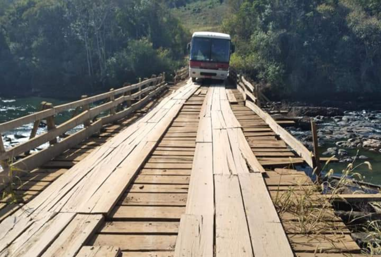 Descaso: trabalhadores precisam descer de ônibus e atravessar a pé ponte de madeira. Veja o vídeo!